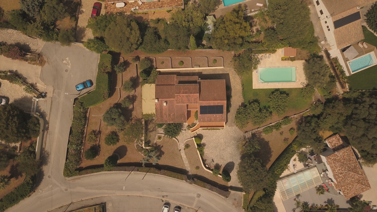Panneaux photovoltaïques alignés sur le pan sud d'une toiture pavillonnaire, vue du ciel